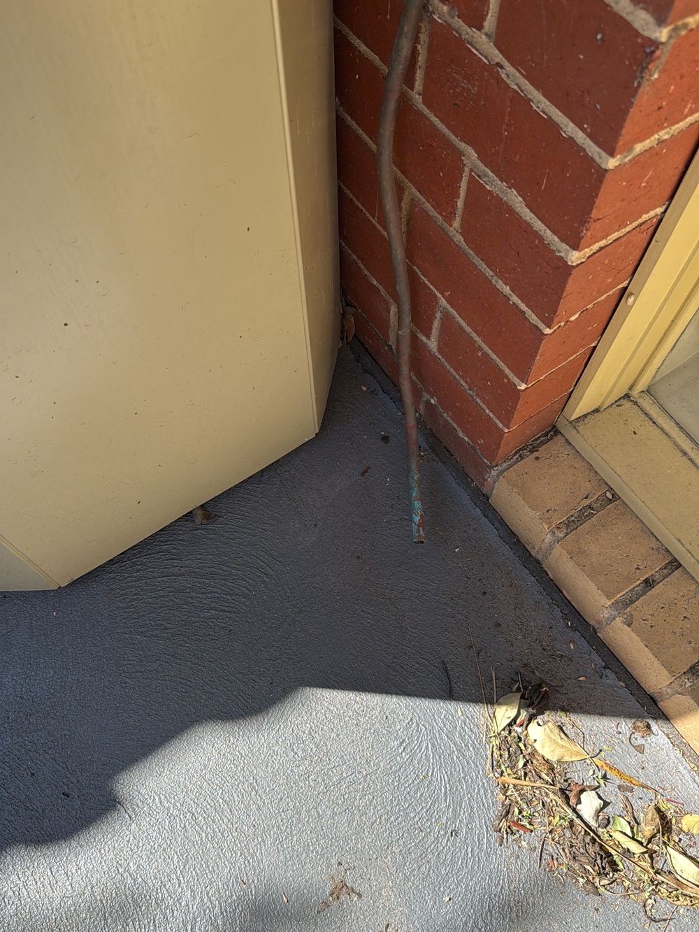 Hot water unit overflow discharging onto the ground beside the wall, Newport, Mambourin