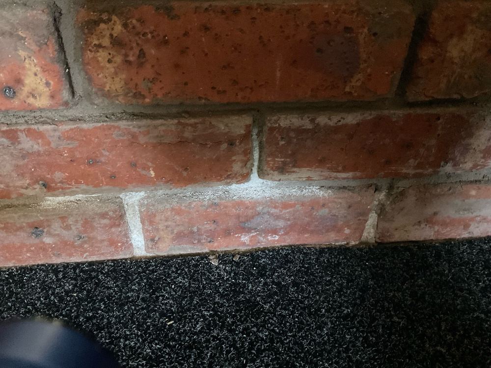Efflorescence at the base of the brickwork, a sign of moisture moving through it, Newport, Mambourin
