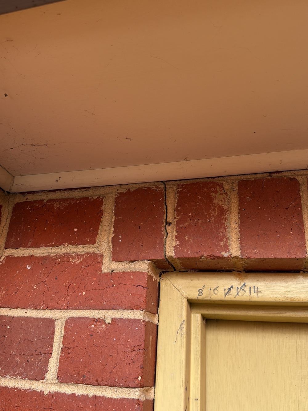 Cracking above the rear garage door where no lintel appears to carry the bricks, Newport, Mambourin