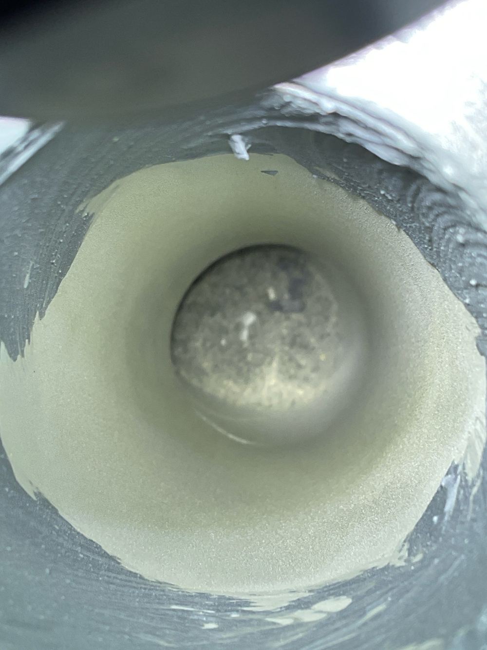 Hardened cement inside the shower drain, with a blockage close, found during a waterproofing inspection in Lara